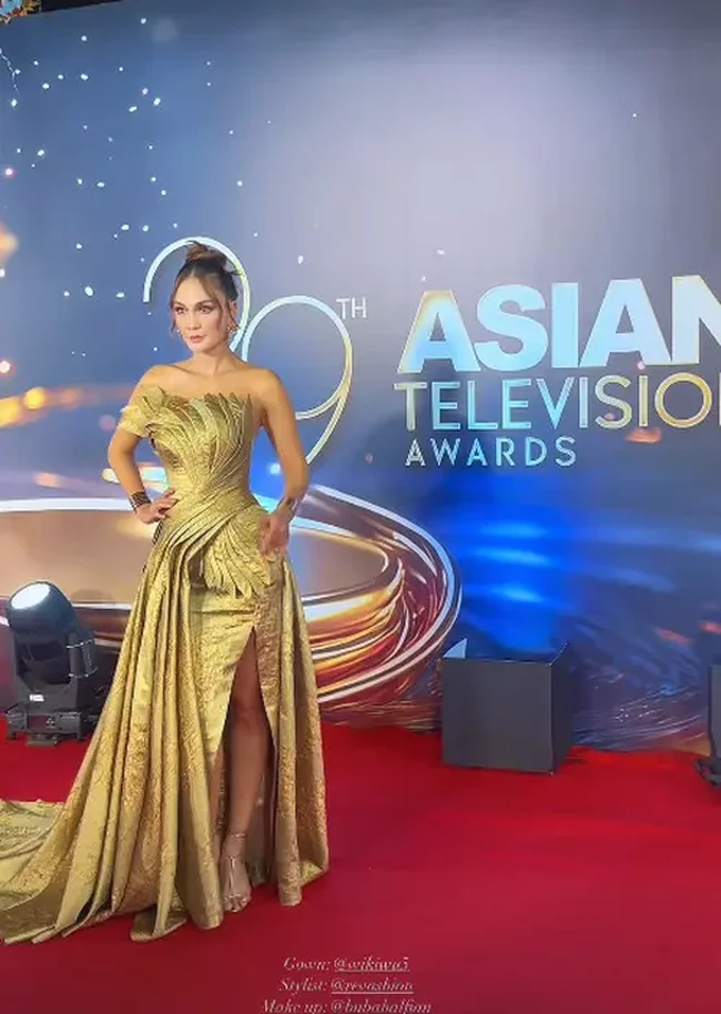 Strapless gown yang dikenakan Luna itu tampak memiliki belahan yang cukup tinggi sampai ke paha. Penampilannya juga makin terlihat glamor dan memukau dengan heels serta anting dan gelang yang juga berwarna emas. Foto: Instagram/@lunamaya