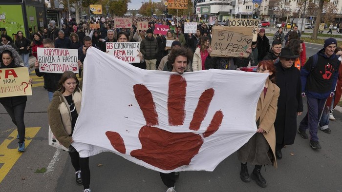 People march during a protest following the collapse of a concrete canopy at the railway station that killed 15 people one month ago, in Novi Sad, Serbia, Sunday, Dec. 1, 2024. (AP Photo/Darko Vojinovic)