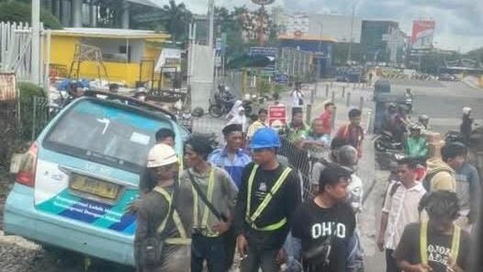 Satu unit angkot terperosok di selokan dekat perlintasan kereta di kawasan Mangga Dua. Peristiwa itu berdampak pada laju KRL dan lalu lintas (lalin). (dok Pribadi/IG @charissahak)