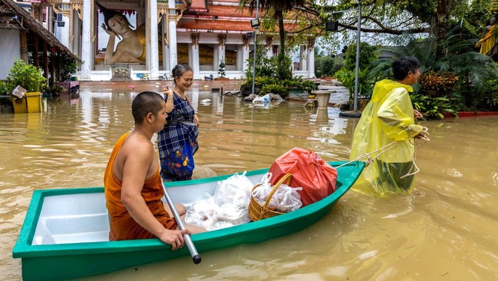 A Buddhist monk and local residents wade through a flooded street at Wat Mahattamangkalaram Temple in Hat Yai district, Songkhla province, Thailand, November 30, 2024. REUTERS/Roylee Suriyaworakul TPX IMAGES OF THE DAY