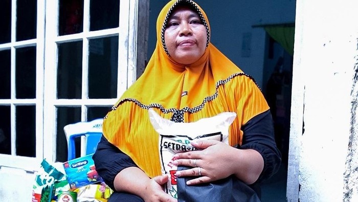 Warga terdampak banjir menerima paket bantuan di kawasan Rawajati, Pancoran, Jakarta Selatan. Bantuan ini diharapkan dapat meringankan beban masyarakat yang terdampak.