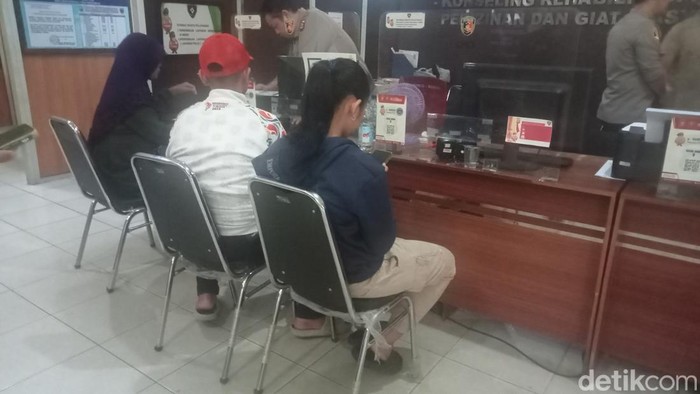 Hasidah (61) didampingi keluarganya saat melapor ke SPKT Polrestabes Palembang.