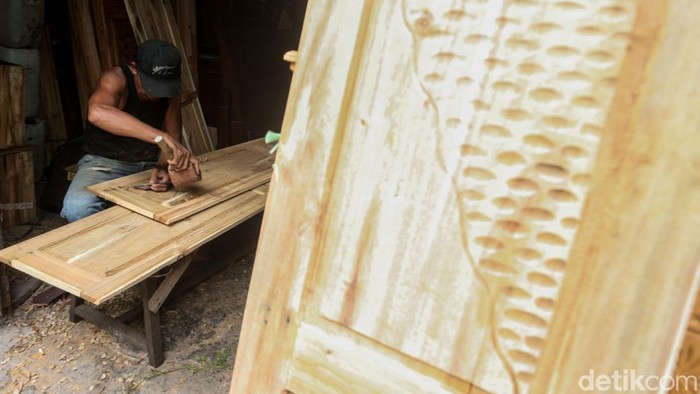 Intip Jasa Ukir Lemari Jepara di Klender Slamet (62) menyelesaikan ukiran pintu di Kawasan Klender, Jakarta Timur, Selasa (3/12/2024).
