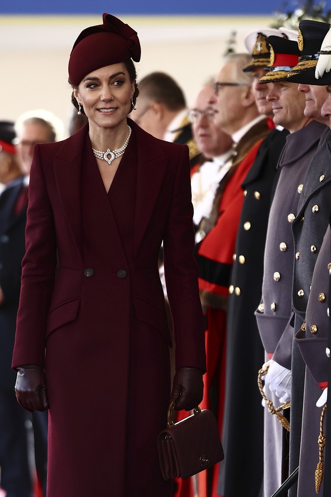 Pilihan busana Kate dianggap sebagai penghormatan kepada Qatar, dengan warna marun yang melambangkan bendera negara tersebut. Sementara itu, mutiara memiliki makna penting dalam budaya Qatar. (Foto: Henry Nicholls via AP, Pool)