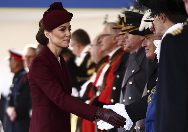 Dalam seremoni tersebut, Kate tampil elegan mengenakan coat dress warna marun rancangan Sarah Burton untuk Alexander McQueen, dipadukan dengan topi senada karya Sahar Millinery. Rambutnya ditata dalam gaya chignon elegan, dilengkapi anting-anting dan kalung mutiara yang pernah dimiliki mendiang Ratu Elizabeth II. (Foto: Henry Nicholls via AP, Pool)