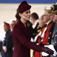 Dalam seremoni tersebut, Kate tampil elegan mengenakan coat dress warna marun rancangan Sarah Burton untuk Alexander McQueen, dipadukan dengan topi senada karya Sahar Millinery. Rambutnya ditata dalam gaya chignon elegan, dilengkapi anting-anting dan kalung mutiara yang pernah dimiliki mendiang Ratu Elizabeth II. (Foto: Henry Nicholls via AP, Pool)
