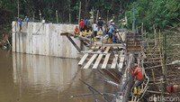 Sejumlah pekerja dan alat berat merampungkan pembangunan dinding turap beton di Sungai Pesanggrahan, Pondok Pinang, Jakarta Selatan, Selasa (3/12/2024).  