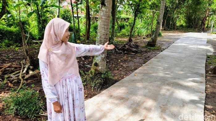Nur Jannah menunjukkan jalan yang dibangunnya dengan dana pribadi di Purworejo, Selasa (3/12/2024).