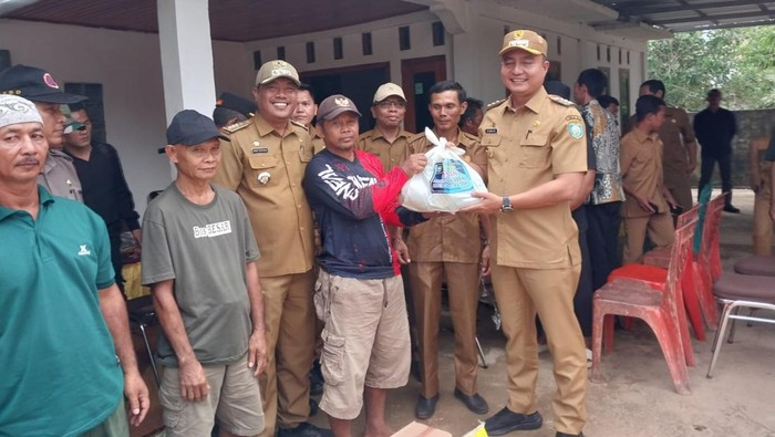 Pj Bupati OKU menyalurkan bantuan kepada warga terdampak bencana angin puting beliung.