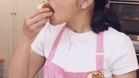 Tepat setelah rotinya jadi, Prilly tak bisa menahan rasa penasaran untuk mencicipi. Roti yang hangat dengan isian padat tampak nikmat disantap oleh Prilly. Foto: Instagram/prillylatuconsina