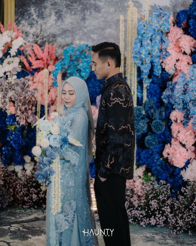 Rizky Ridho terlihat tampan mengenakan atasan Batik dengan celana hitam. Sedangkan hendy Aulia memakai dress biru muda dengan sulaman bunga dan detail renda yang manis romantis. Foto: Haunty Photostory/Instagram Rizky Ridho