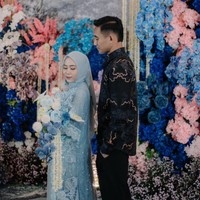 Rizky Ridho terlihat tampan mengenakan atasan Batik dengan celana hitam. Sedangkan hendy Aulia memakai dress biru muda dengan sulaman bunga dan detail renda yang manis romantis. Foto: Haunty Photostory/Instagram Rizky Ridho