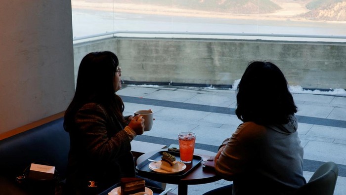 Sensasi Ngopi di Perbatasan Korea Utara Customers queue up in front of the new store of Starbucks at the top of the Aegibong Peak Observatory, south of the demilitarized zone (DMZ), separating the two Koreas, in Gimpo, South Korea, November 29, 2024. REUTERS/Kim Soo-hyeon