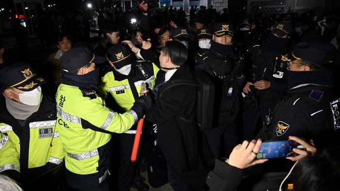 Police struggle with people trying to enter the National Assembly in front of the main gate of the National Assembly in Seoul, South Korea on December 3, 2024, after South Koreas President Yoon Suk Yeol declared emergency martial law. South Koreas President Yoon Suk Yeol on December 3 declared emergency martial law, saying the step was necessary to protect the country from communist forces amid parliamentary wrangling over a budget bill. (Photo by JUNG YEON-JE / AFP)