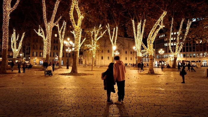 People walk amongst trees illuminated for the Christmas season at the Parque del Arenal, Bilbao, Spain, December 2, 2024. REUTERS/Vincent West