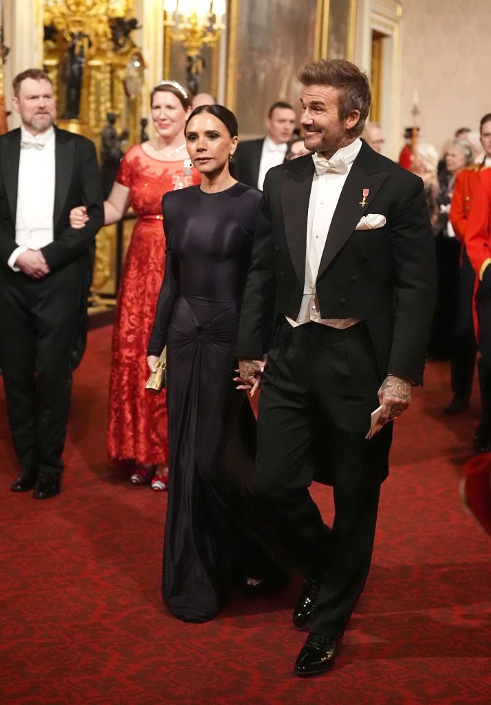 LONDON, ENGLAND - DECEMBER 3: Victoria and David Beckham make their way along the East Gallery to attend the State Banquet at Buckingham Palace during day one of The Amir of the State of Qatar's visit to the United Kingdom on December 3, 2024 in London, England. His Highness Sheikh Tamim bin Hamad Al Thani, Amir of the State of Qatar, accompanied by Her Highness Sheikha Jawaher bint Hamad bin Suhaim Al Thani, will hold several engagements with The Prince and Princess of Wales, The King and Queen as well as political figures. (Photo by WPA Pool/Getty Images)