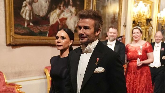 LONDON, ENGLAND - DECEMBER 3: Victoria and David Beckham make their way along the East Gallery to attend the State Banquet at Buckingham Palace during day one of The Amir of the State of Qatars visit to the United Kingdom on December 3, 2024 in London, England. His Highness Sheikh Tamim bin Hamad Al Thani, Amir of the State of Qatar, accompanied by Her Highness Sheikha Jawaher bint Hamad bin Suhaim Al Thani, will hold several engagements with The Prince and Princess of Wales, The King and Queen as well as political figures. (Photo by WPA Pool/Getty Images)