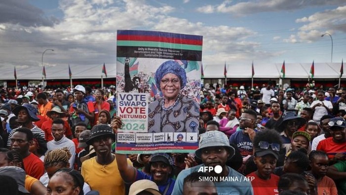 (FILES) Supporters of the South West Africa Peoples Organisation (SWAPO) presidential candidate Netumbo Nandi-Ndaitwah hold her portrait as they take part in a campaign rally in Windhoek on November 24, 2024, ahead of Namibias general election due on November 27 to elect a new president and members of the National Assembly. Namibias Vice-President Netumbo Nandi-Ndaitwah from the ruling SWAPO party has won presidential elections with 57.31 percent of the vote, the election commission announced on December 3, 2024. (Photo by SIMON MAINA / AFP)