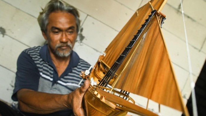 Perajin membuat miniatur kapal pinisi di Desa Ketapang, Mauk, Kabupaten Tangerang, Banten, Rabu (4/12/2024). Miniatur kapal pinisi yang terbuat dari kayu jati dan limbah kayu palet tersebut membutuhkan waktu sekitar 10 hari kerja yang dibanderol dengan harga Rp700 ribu-Rp1 juta tergantung ukurannya. ANTARA FOTO/Sulthony Hasanuddin/Spt.