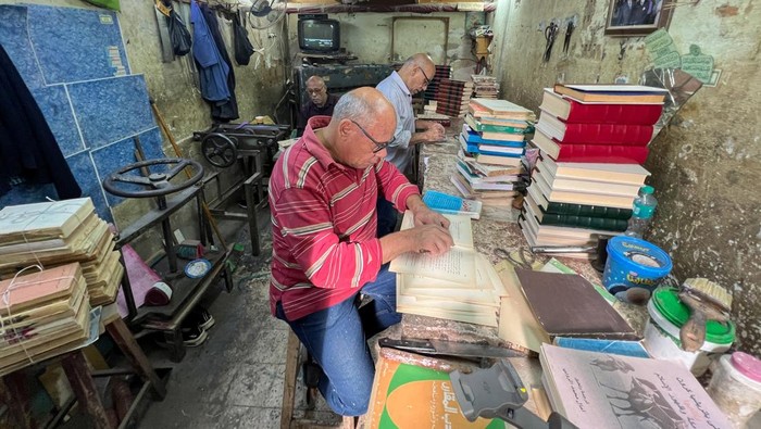 Melihat Bengkel Restorasi Buku Lama di Kairo Mohammed Zaki, 69, restores century-old books that have been damaged at his own books workshop at his neighbourhood of Darb al-Ahmar in Cairo, Egypt November 21, 2024. Zaki works on rebinding and renovating books, some of which he says are over a century old while using handmade crafting, which he says makes the restoration process more accurate and valuable, while restored and renovated over 1,000 books throughout the years. REUTERS/Amr Abdallah Dalsh