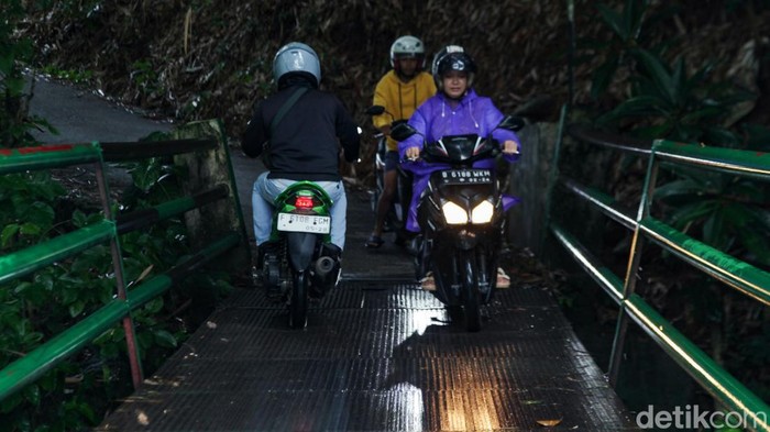 Jalan Tebing menjadi jalan tembus favorit pemotor di perbatasan Depok dan Bogor. Jalan yang membelah Kali Angke ini sempit dan licin.