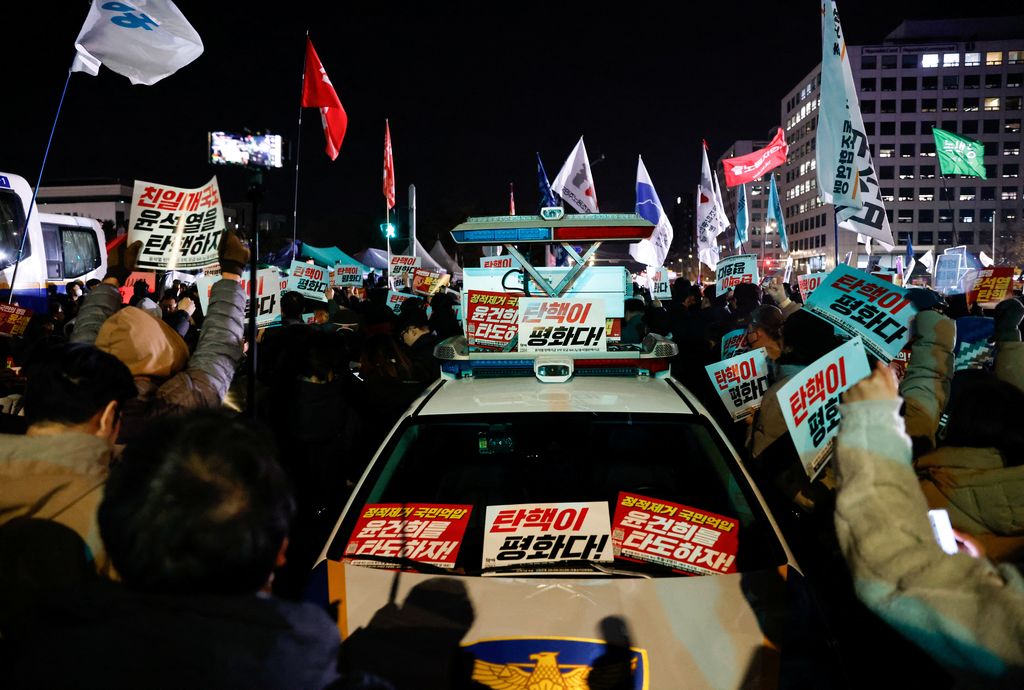 Plakat dipasang di kendaraan polisi saat orang-orang berkumpul di luar Majelis Nasional, setelah Presiden Korea Selatan Yoon Suk Yeol mengumumkan darurat militer, di Seoul, Korea Selatan, 4 Desember 2024. (REUTERS/Kim Soo-hyeon)