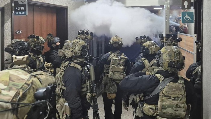 National Assembly employees spray a fire extinguisher towards soldiers at the National Assembly in Seoul, South Korea, Wednesday, Dec. 4, 2024. (Cho Da-un/Yonhap via AP)