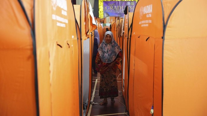 Puluhan Ribu Warga Malaysia Mengungsi Akibat Banjir Terburuk Women rest inside a tent set up as a temporary shelter for those affected by the flood in Tumpat, on the outskirts of Kota Bahru in Kelantan state on the east coast of Malaysia, Wednesday, Dec. 4, 2024. (AP Photo/Vincent Thian)