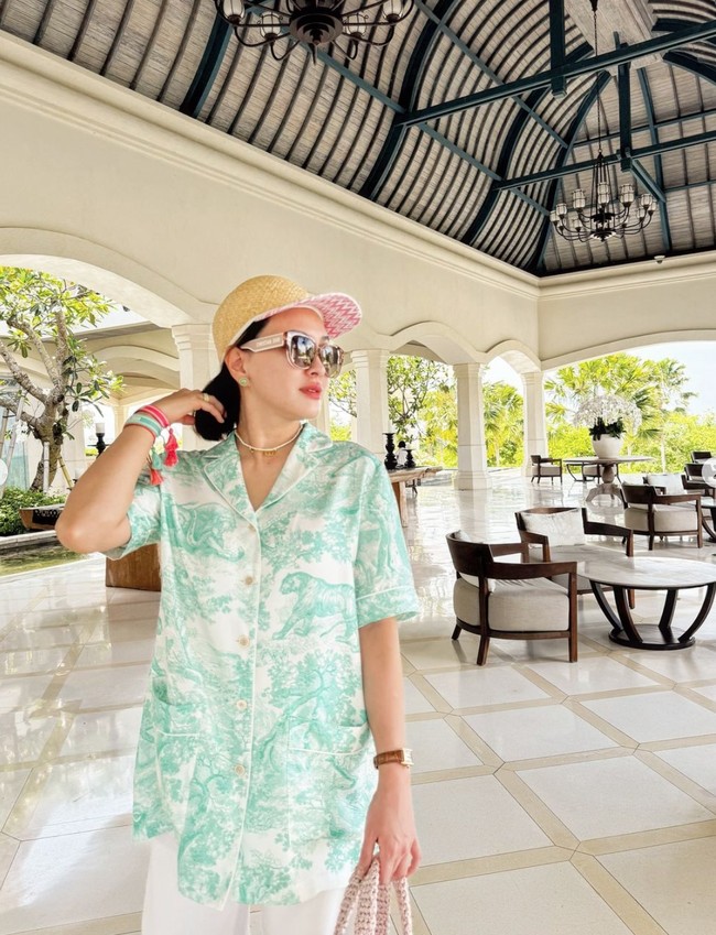 Di kesempatan lain Shandy tampak memadukan kemeja santai bergambar hewan dan tumbuhan di hutan dengan celana panjang putih. Penampilannya tersebut juga tak kalah menawan dari penampilan sebelumnya. Foto: Instagram/@shandyaulia