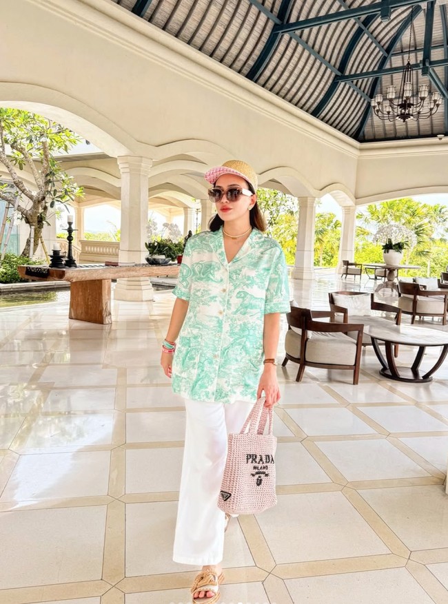 Melengkapi gayanya, Shandy tampak menenteng tote bag rajut berwarna coklat muda dari merek mewah Prada. Foto: Instagram/@shandyaulia