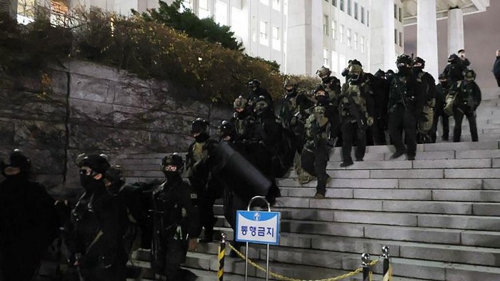 Soldiers withdraw from the National Assembly in Seoul on December 4, 2024, after the passage of a resolution during an emergency plenary session urging South Korea President Yoon Suk Yeol to revoke martial law. Yoon on December 3 declared martial law, accusing the opposition of being 