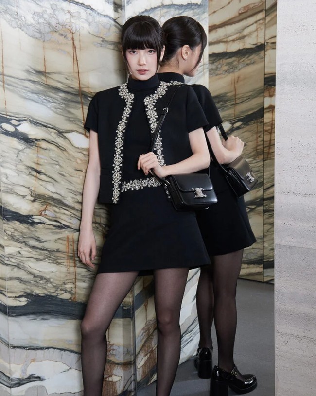 Suzy tampil elegan dalam balutan busana serba hitam CELINE. Dia memakai atasan berkerah, paduan Embroided Chelsea Jacket, dan mini skirt yang serasi. Penampilannya semakin mewah dengan anting-anting dan cincin dari Chaumet. Foto: dok. CELINE