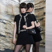 Suzy tampil elegan dalam balutan busana serba hitam CELINE. Dia memakai atasan berkerah, paduan Embroided Chelsea Jacket, dan mini skirt yang serasi. Penampilannya semakin mewah dengan anting-anting dan cincin dari Chaumet. Foto: dok. CELINE