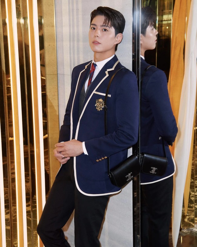 Park Bo Gum tampil menawan dalam balutan jas berwarna navy, vest berwarna abu-abu, dan dasi bermotif stripes dari koleksi CELINE Men Summer 2025 show. Foto: dok. CELINE