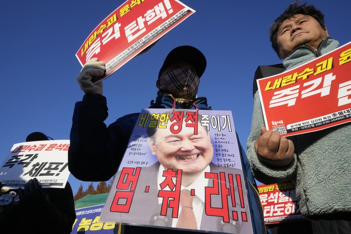 Protesters attend a rally to demand South Korean President Yoon Suk Yeol to step down in front of the National Assembly in Seoul, South Korea, Wednesday, Dec. 4, 2024. The signs read Stop. (AP Photo/Ahn Young-joon)