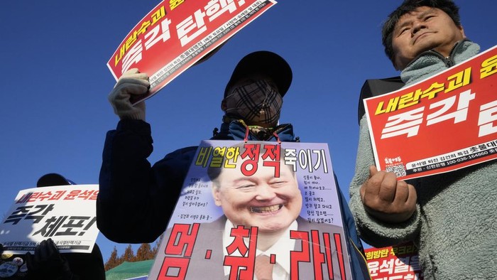 Protesters attend a rally to demand South Korean President Yoon Suk Yeol to step down in front of the National Assembly in Seoul, South Korea, Wednesday, Dec. 4, 2024. The signs read 
