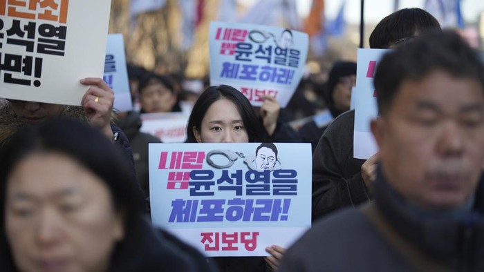 South Koreans hold signs reading 
