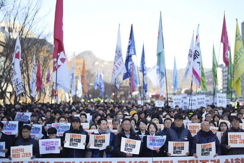 South Koreans hold signs reading 