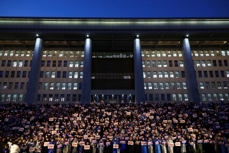 People hold candles and signs during a candlelight vigil to demand the resignation of South Korean President Yoon Suk Yeol, who declared martial law which was reversed hours later, at the National Assembly in Seoul, South Korea, December 5, 2024. REUTERS/Kim Hong-ji     TPX IMAGES OF THE DAY