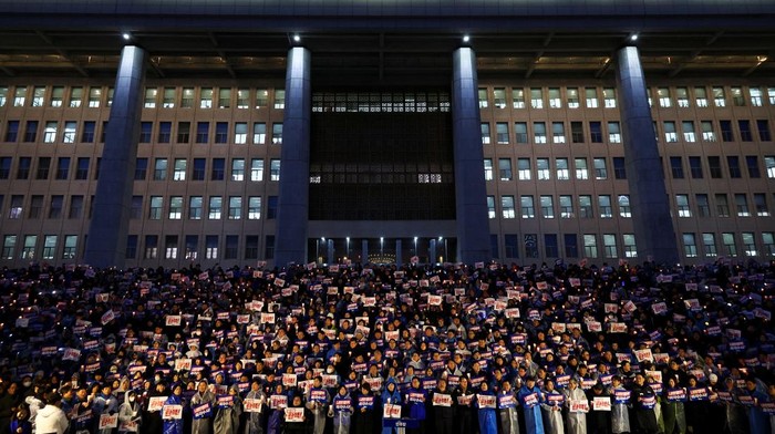 Aksi Nyala Lilin Warga Korsel Desak Presiden Yoon Suk Yeol Mundur People hold candles and signs during a candlelight vigil to demand the resignation of South Korean President Yoon Suk Yeol, who declared martial law which was reversed hours later, at the National Assembly in Seoul, South Korea, December 5, 2024. REUTERS/Kim Hong-ji TPX IMAGES OF THE DAY