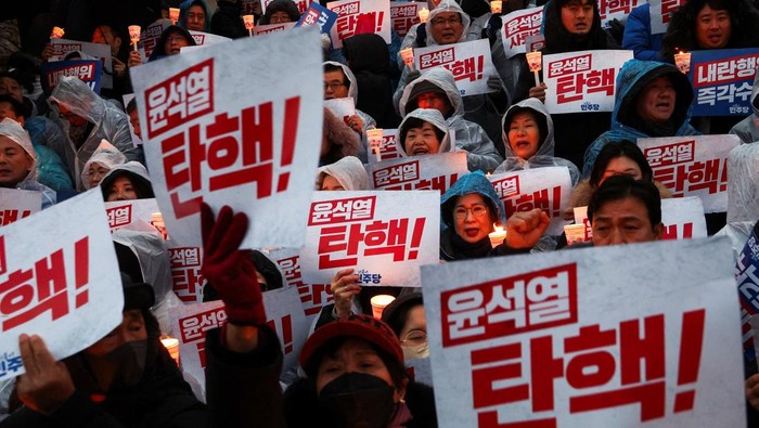 People hold candles and signs during a candlelight vigil to demand the resignation of South Korean President Yoon Suk Yeol, who declared martial law which was reversed hours later, at the National Assembly in Seoul, South Korea, December 5, 2024. REUTERS/Kim Hong-ji     TPX IMAGES OF THE DAY