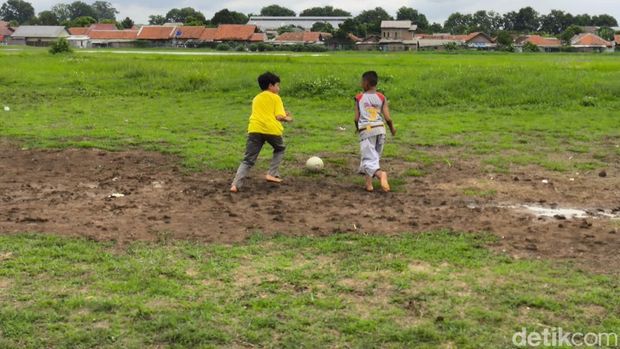 Anak-anak sedang bermain bola di lapangan udara Penggung