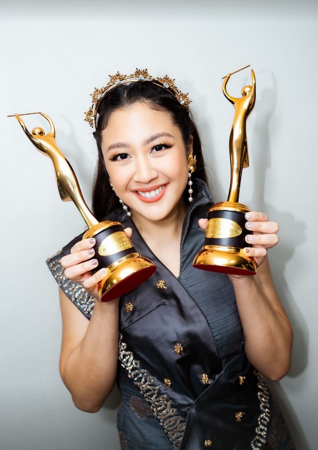 Sherina Munaf yang diganjar dua piala AMI Awards 2024 mengenakan busana abu-abu metalik bordiran silver. Headpiece warna emas dan anting mutiara melengkapi busananya. Foto: Instagram