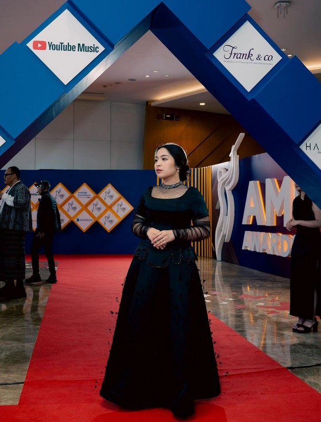 Bernadya memborong empat piala AMI Awards 2024, salah satunya Album Terbaik Terbaik. Pelantun lagu ‘Untungnya, Hidup Harus Tetap Berjalan’ ini tampil cantik berbalut gaun hitam dengan aksen transparan di lengan. Foto: Instagram