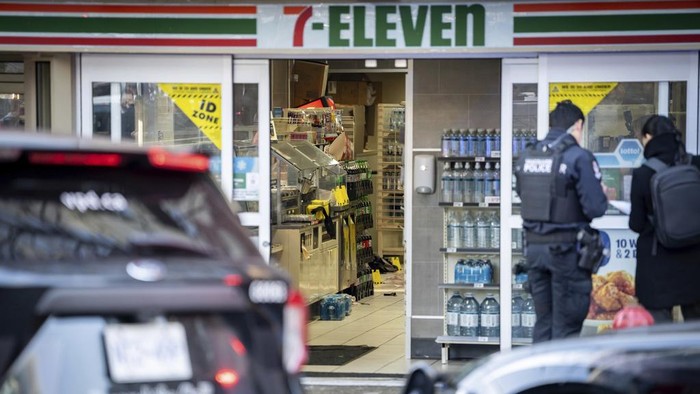 A Vancouver Police officer documents a crime scene in a 7-Eleven in Vancouver, British Columbia, Wednesday, Dec. 4, 2024. (Ethan Cairns/The Canadian Press via AP)