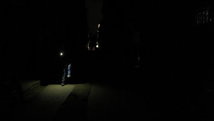 Jaringan Listrik di Kuba Runtuh, Satu Negara Gelap Gulita A man walks on the street during an electrical grid collapse, in Havana, Cuba, December 4, 2024. REUTERS/Alexandre Meneghini TPX IMAGES OF THE DAY