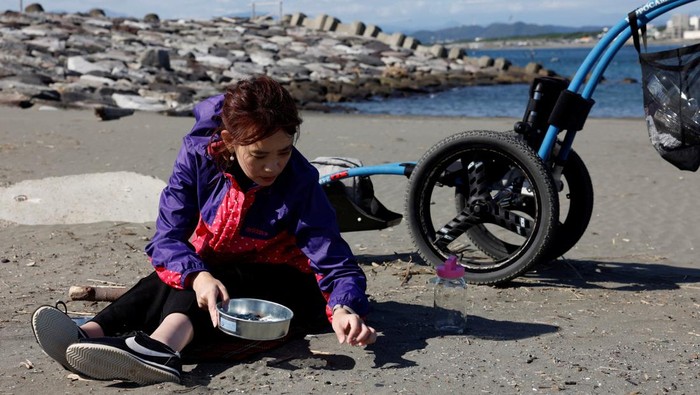 Japanese manicurist Naomi Arimoto presses a false nail with a decorative nail tip using plastic waste which she collected from the beach, onto a thumb of a customer at her nail salon in Chigasaki, Kanagawa Prefecture, Japan October 21, 2024. REUTERS/Manami Yamada