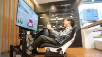 Pengunjung mencoba simulator mobil di Nissan Gallery, Jakarta, Kamis (5/12/2024).  