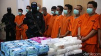 Para tersangka diborgol dan tertunduk lesu saat dihadirkan dalam jumpa pers.  