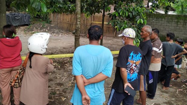 Warga melihat rumah sekeluarga di Kediri yang tewas bersimbah darah dan sudah dipasangi garis polisi.